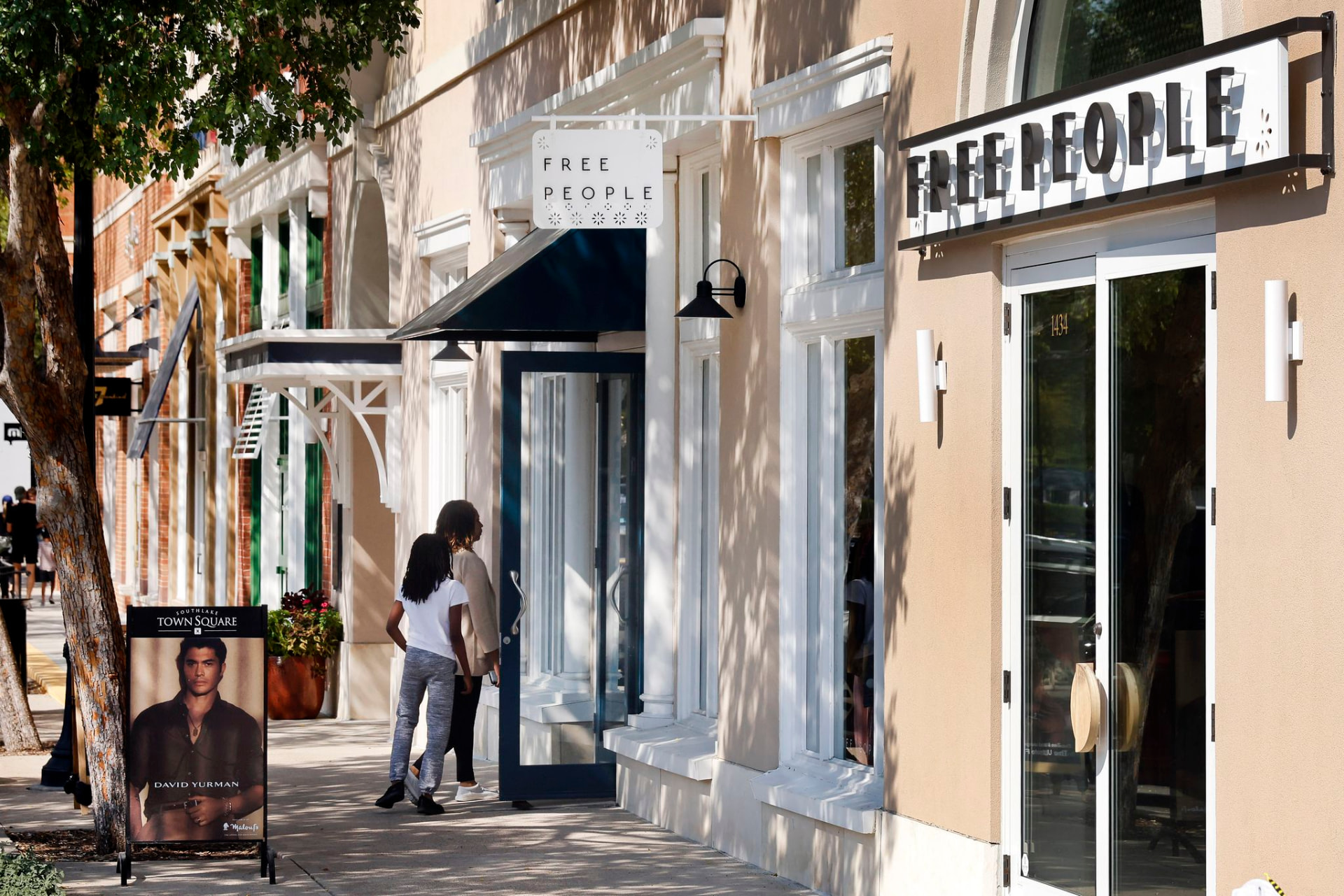 Shoppers walking past storefronts in Southlake Town Square