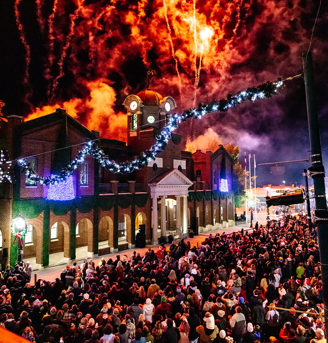 Fireworks above Grapevine's historic city hall during a crowded Christmas lighting celebration