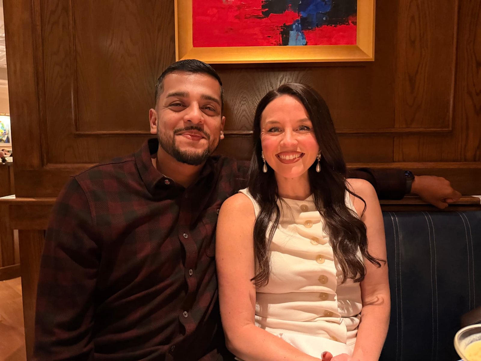 Alyssa and Hector Hidalgo seated in a wood-paneled booth at Hudson House Southlake